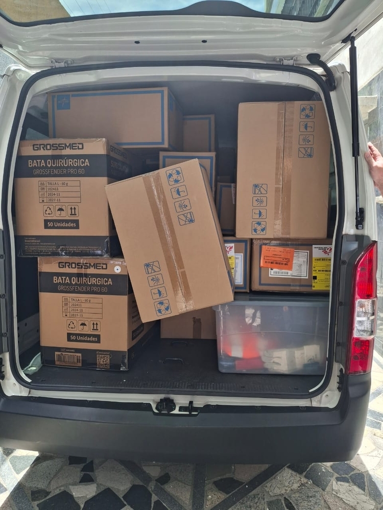 Une fourgonnette dont le hayon est ouvert est chargée de boîtes de fournitures. 