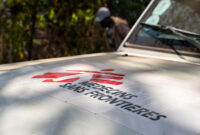 Gros plan sur le logo de MSF sur le capot d’un véhicule blanc.