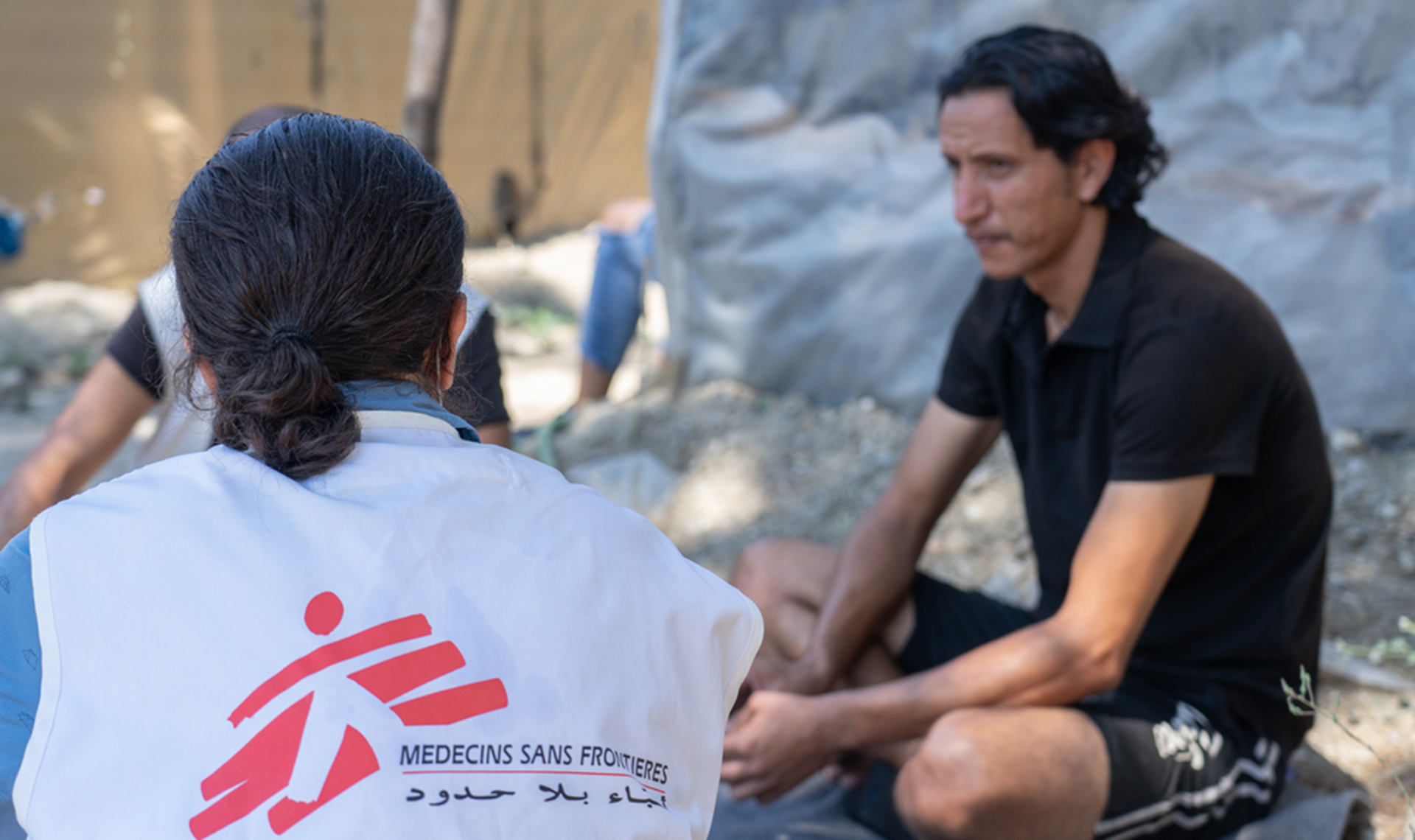 Un membre du personnel MSF discute avec un homme qui a fui la Syrie dans le camp de réfugiés de Vathy, sur l