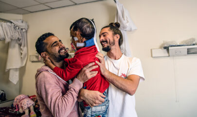 Une enfant dont le visage a été brûlé dans une explosion, avec son frère et un kinésithérapeute MSF en Jordanie.